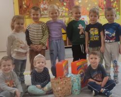 dzieci pozujące z darami na akcję "Świąteczna paczka"