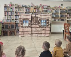 dzieci i bibliotekarka podczas zajęć w bibliotece