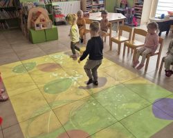 dzieci i bibliotekarka podczas zajęć w bibliotece