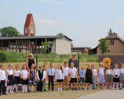 fotografie przedstawiajaće dzieci i dorosłych podczas uroczystości zakończenia roku szkolnego