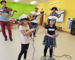 zdjęcia dzieci uczestniczących w zajęciach muzycznych w sali i plenerze