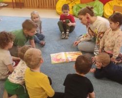 dzieci i rodzice podczas głośnego czytania literatury dziecięcej