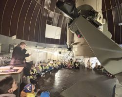 dzieci i dorośli podczas wizyty w obserwatorium astronomicznym