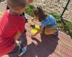 dzieci rysują kredą po chodniku