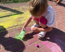 dzieci rysują kredą po chodniku