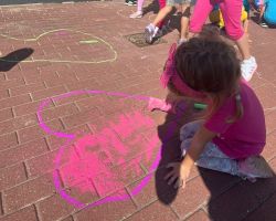 dzieci rysują kredą po chodniku