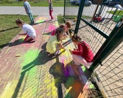 dzieci rysują kredą po chodniku