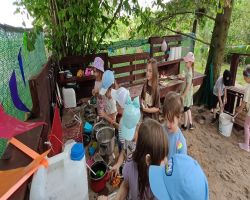 dzieci zwiedzają zagrodę edukacyjną