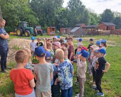 dzieci zwiedzają zagrodę edukacyjną