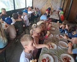 dzieci zwiedzają zagrodę edukacyjną