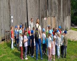 dzieci zwiedzają zagrodę edukacyjną