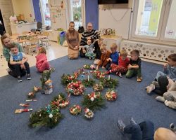 dzieci i rodzice tworzą stroiki podczas warsztatów świątecznych w przedszkolu