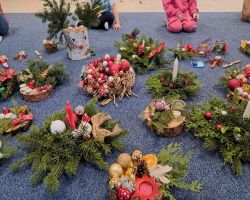 dzieci i rodzice tworzą stroiki podczas warsztatów świątecznych w przedszkolu