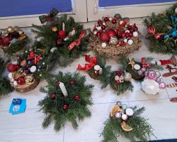 dzieci i rodzice tworzą stroiki podczas warsztatów świątecznych w przedszkolu