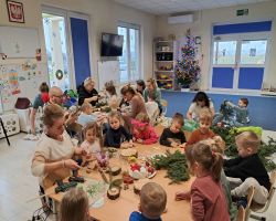 dzieci i rodzice tworzą stroiki podczas warsztatów świątecznych w przedszkolu