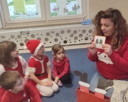 dzieci i nauczyciel podczas zajęć z języka angielskiego o Świętym Mikołaju