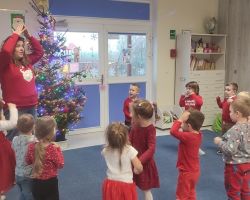 dzieci i nauczyciel podczas zajęć z języka angielskiego o Świętym Mikołaju