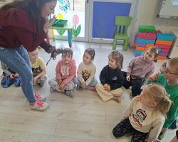 dzieci podczas spotkania z żywymi zwierzętami kangurem, agamom, królikiem