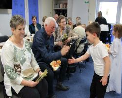 seniorzy oglądają występy dzieci
