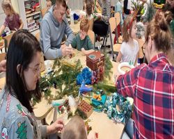 dzieci i rodzice tworzą stroiki świąteczne podczas zajęć otwartych