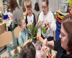 dzieci i rodzice tworzą stroiki świąteczne podczas zajęć otwartych