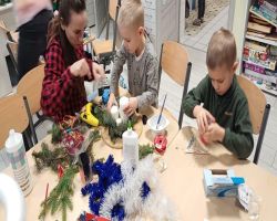 dzieci i rodzice tworzą stroiki świąteczne podczas zajęć otwartych