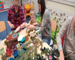 dzieci i rodzice tworzą stroiki świąteczne podczas zajęć otwartych