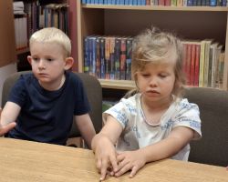 dzieci podczas zajęć czytelniczych w bibliotece