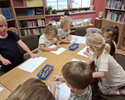 dzieci podczas zajęć czytelniczych w bibliotece