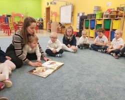 dzieci i rodzice podczas głośnego czytania literatury dziecięcej