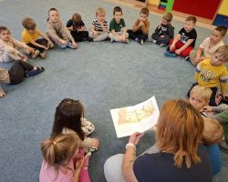 dzieci i rodzice podczas głośnego czytania literatury dziecięcej