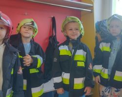 dzieci i dorośli podczas wycieczki do straży pożarnej