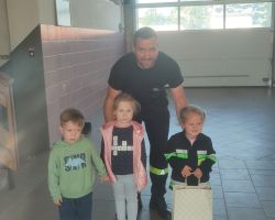 dzieci i dorośli podczas wycieczki do straży pożarnej