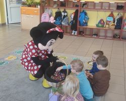 dzieci, dorośli i postać myszki minnie podczas obchodów dnia kobiet