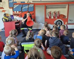 dzieci i dorośli podczas wycieczki do straży pożarnej