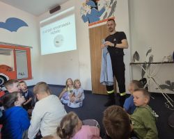 dzieci i dorośli podczas wycieczki do straży pożarnej