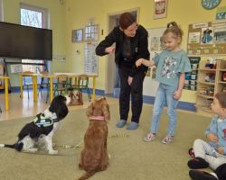dzieci, teraputa i dwa psy podczas zajęć z dogoterapii