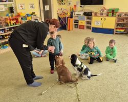 dzieci, teraputa i dwa psy podczas zajęć z dogoterapii