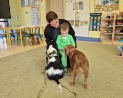 dzieci, teraputa i dwa psy podczas zajęć z dogoterapii