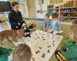 dzieci, teraputa i dwa psy podczas zajęć z dogoterapii