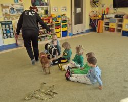 dzieci, teraputa i dwa psy podczas zajęć z dogoterapii