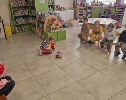 dzieci i bibliotekarka podczas zajęć w bibliotece