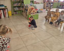 dzieci i bibliotekarka podczas zajęć w bibliotece