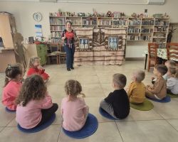 dzieci i bibliotekarka podczas zajęć w bibliotece