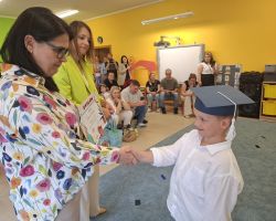 dzieci i nauczyciele podczas uroczystości zakończenia roku szkolnego