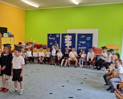 dzieci i nauczyciele podczas uroczystości zakończenia roku szkolnego