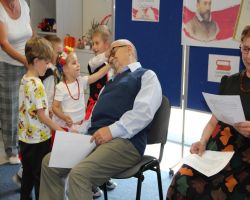 dzieci słuchają czytania seniorów w ramach Narodowego Czytania