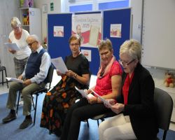 dzieci słuchają czytania seniorów w ramach Narodowego Czytania