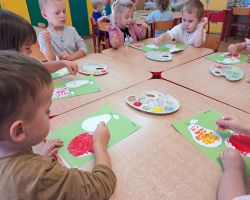 dzieci wykonują pracę plastyczną - malowanie konturu jabłka