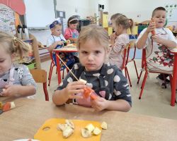 dzieci podczas wykonywania owocowych szaszłyków